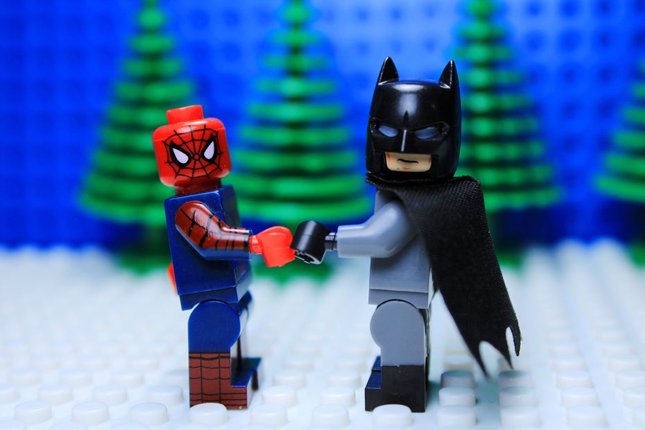 Symbolbild: Zwei Legofiguren geben sich die Hand. Eine der Figuren ist Batman, die andere Spiderman. 